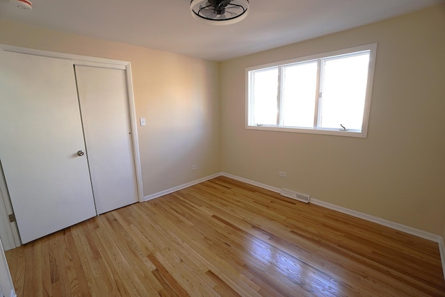 unfurnished bedroom with a closet and light hardwood / wood-style flooring