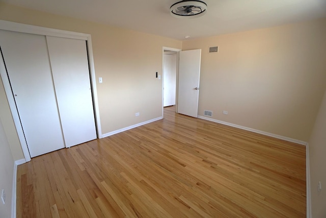 unfurnished bedroom featuring light hardwood / wood-style flooring and a closet