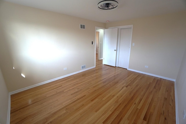 unfurnished bedroom featuring a closet and light wood-type flooring