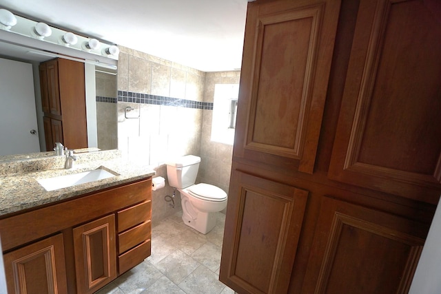 bathroom with vanity, walk in shower, tile walls, and toilet