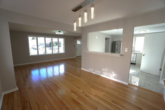 unfurnished living room with a wealth of natural light and light hardwood / wood-style flooring