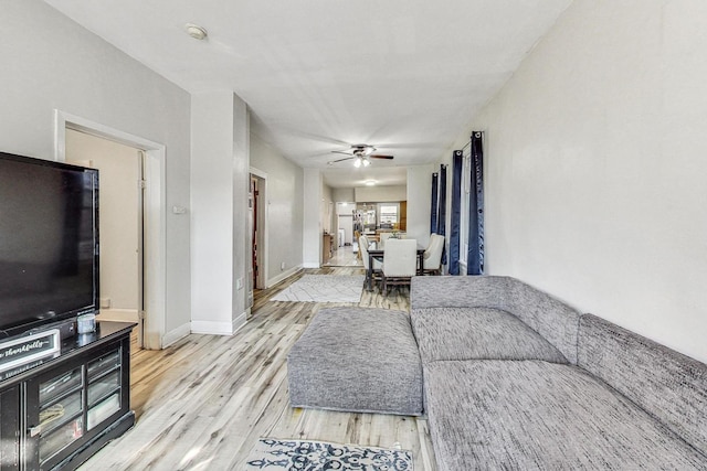 living room featuring ceiling fan and light hardwood / wood-style flooring