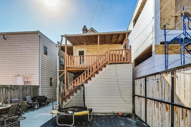 back of house with a trampoline and a patio area