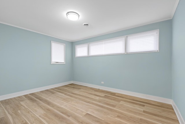 empty room with light hardwood / wood-style flooring and ornamental molding