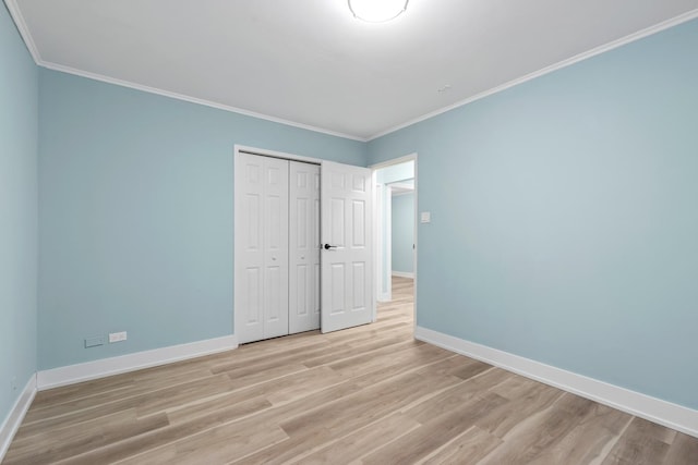 unfurnished bedroom featuring a closet, light hardwood / wood-style flooring, and crown molding