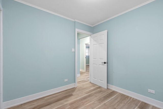 empty room featuring light hardwood / wood-style flooring and crown molding