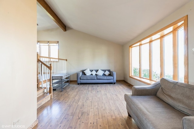 living room featuring lofted ceiling with beams and light hardwood / wood-style floors