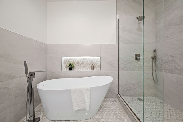 bathroom featuring tile walls, tile patterned floors, and separate shower and tub