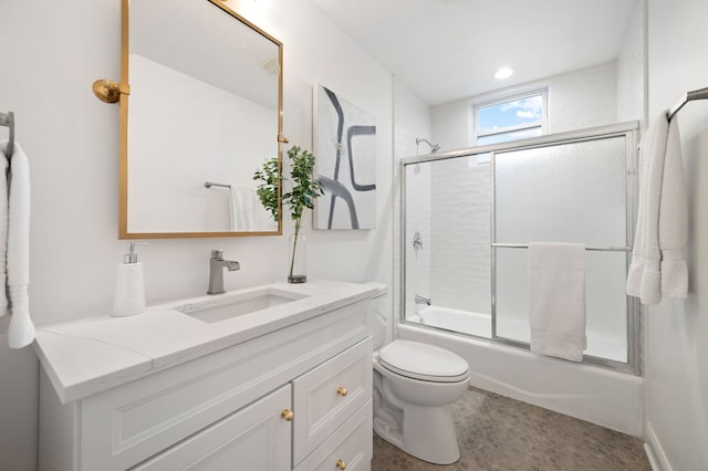 full bathroom featuring vanity, enclosed tub / shower combo, and toilet