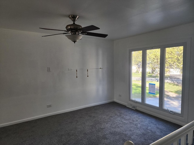 spare room with dark colored carpet and ceiling fan