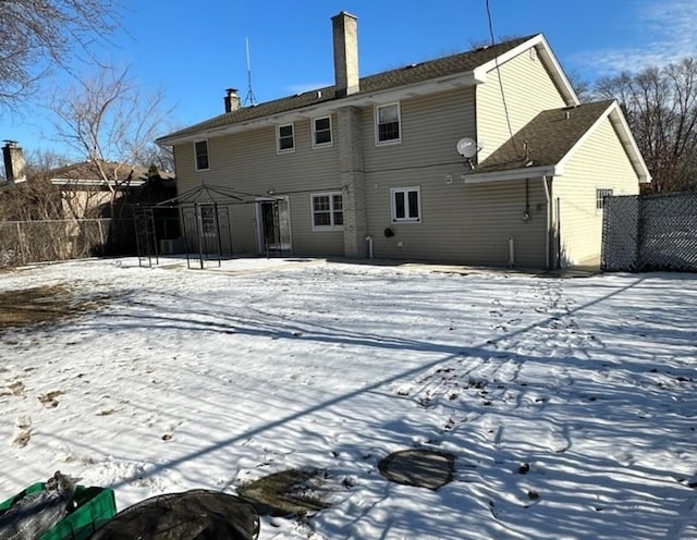 snow covered rear of property featuring a gazebo