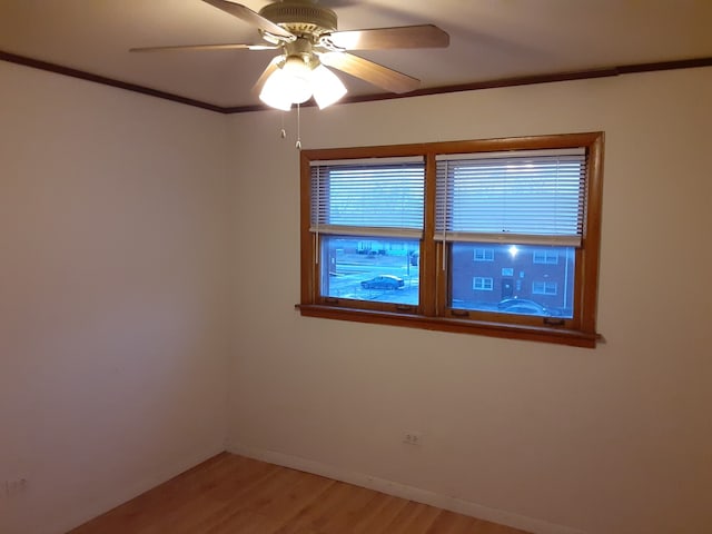 spare room featuring wood-type flooring, ceiling fan, and crown molding