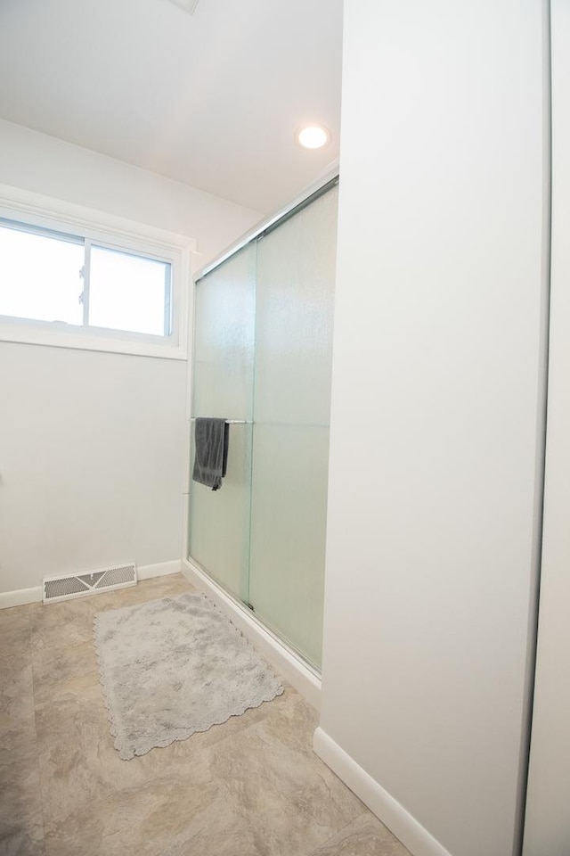 bathroom featuring a shower with door