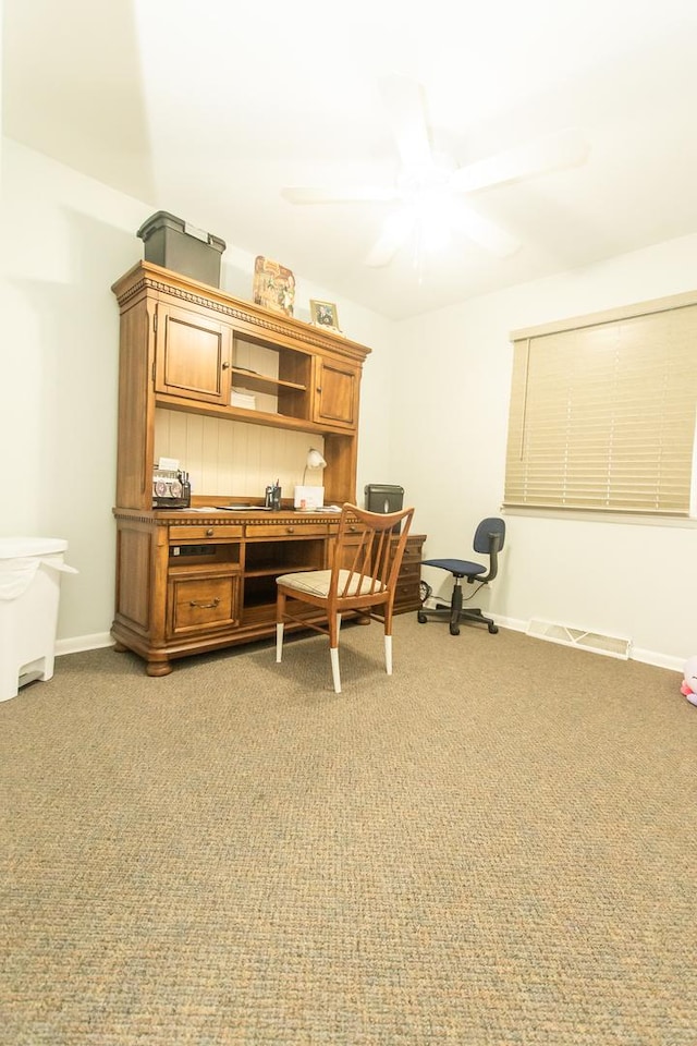 carpeted office space featuring ceiling fan