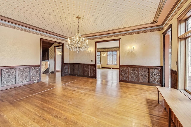 unfurnished dining area featuring wood-type flooring and an inviting chandelier