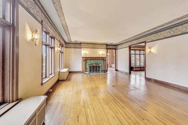 unfurnished living room featuring ornamental molding and light wood-type flooring