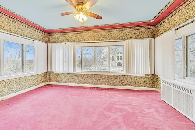 unfurnished sunroom featuring ceiling fan, a healthy amount of sunlight, and radiator