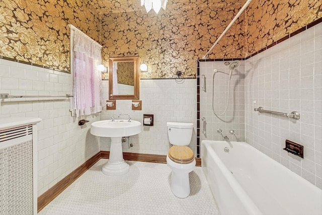 bathroom with toilet, tiled shower / bath combo, tile patterned flooring, and tile walls