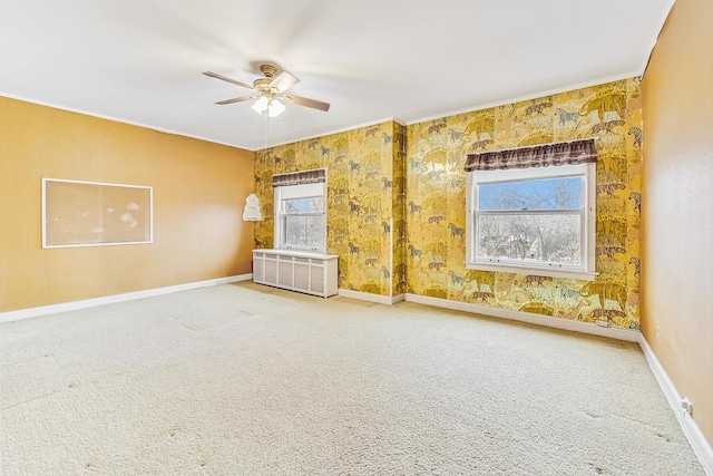 spare room featuring ceiling fan, a healthy amount of sunlight, carpet, and radiator heating unit