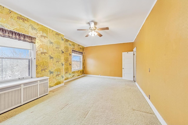 carpeted spare room featuring ornamental molding, radiator, and ceiling fan