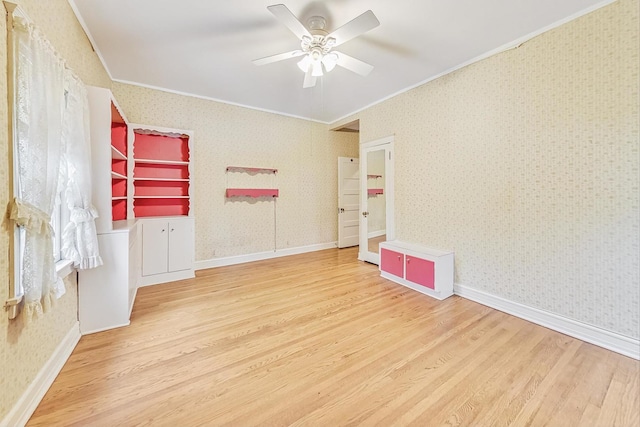 empty room featuring crown molding, ceiling fan, hardwood / wood-style floors, and built in features