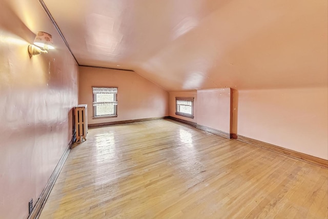 bonus room with lofted ceiling and light hardwood / wood-style floors