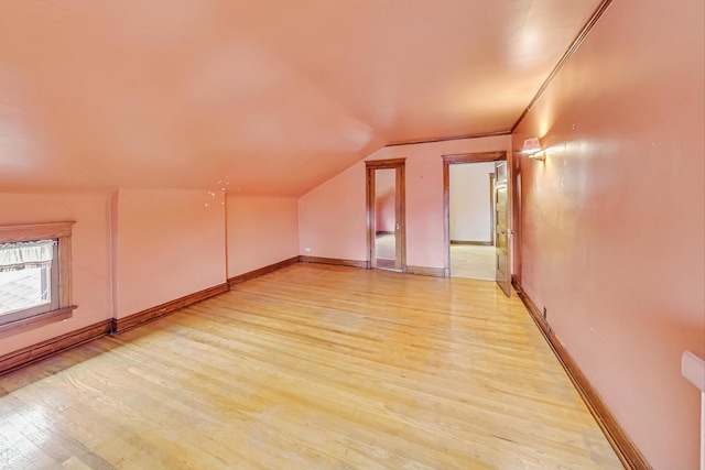 bonus room with vaulted ceiling and light hardwood / wood-style flooring