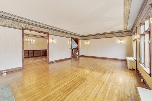 unfurnished room with radiator heating unit, hardwood / wood-style floors, and a chandelier