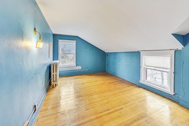 bonus room featuring vaulted ceiling and light wood-type flooring