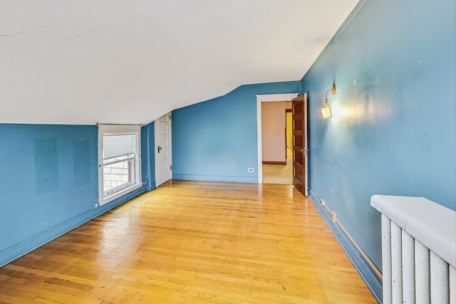 bonus room featuring vaulted ceiling and light wood-type flooring