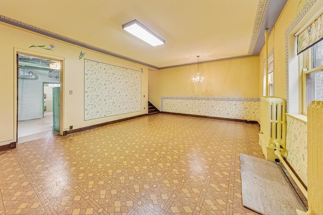 unfurnished room featuring radiator, a notable chandelier, and ornamental molding