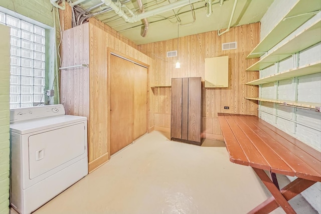 clothes washing area featuring washer / clothes dryer and wooden walls