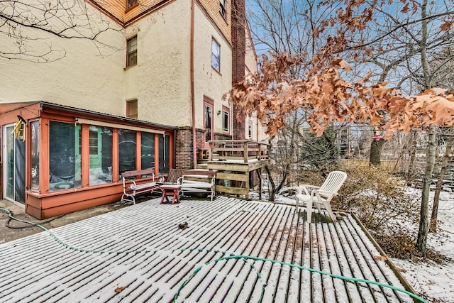 snow covered patio with a sunroom