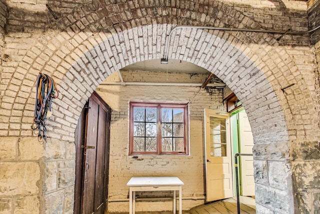 hallway featuring brick wall