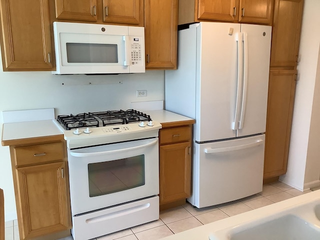 kitchen with light tile patterned flooring and white appliances