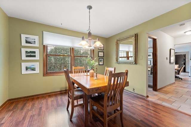 dining room featuring dark wood-type flooring and an inviting chandelier