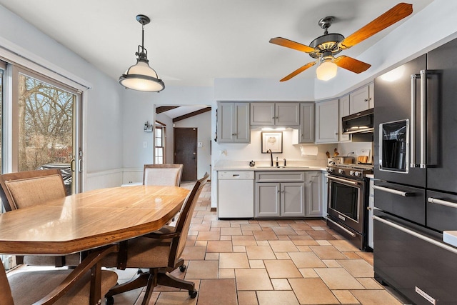 kitchen featuring decorative light fixtures, sink, premium appliances, and gray cabinets