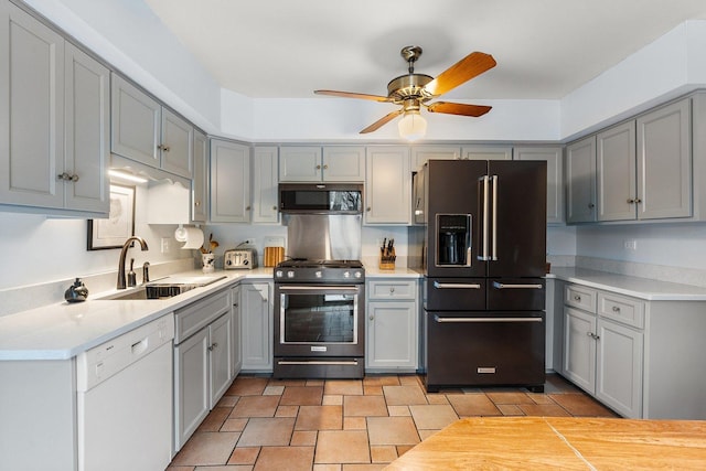 kitchen featuring ceiling fan, sink, gray cabinetry, and high quality appliances