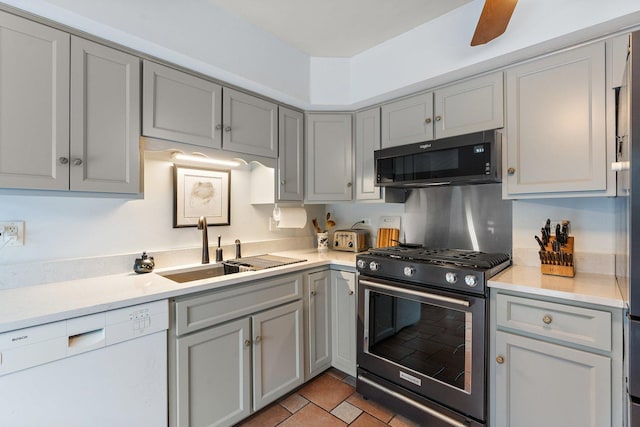 kitchen with dishwasher, gas stove, sink, light tile patterned floors, and gray cabinetry