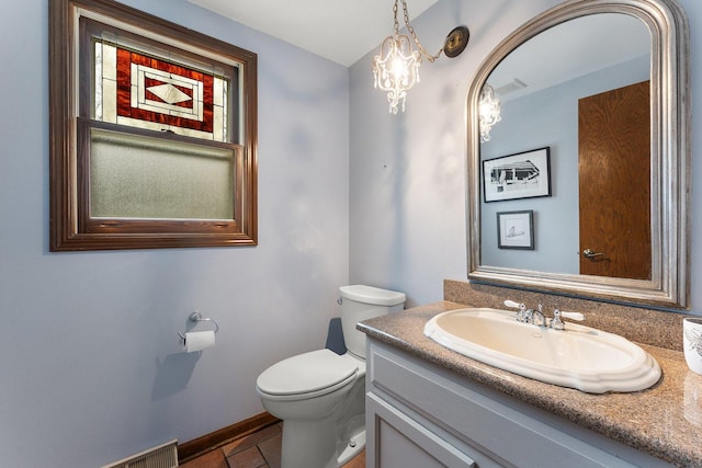 bathroom with an inviting chandelier, toilet, tile patterned floors, and vanity