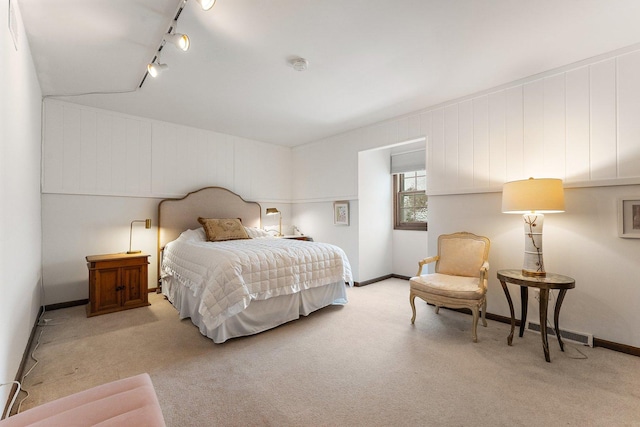 carpeted bedroom featuring track lighting