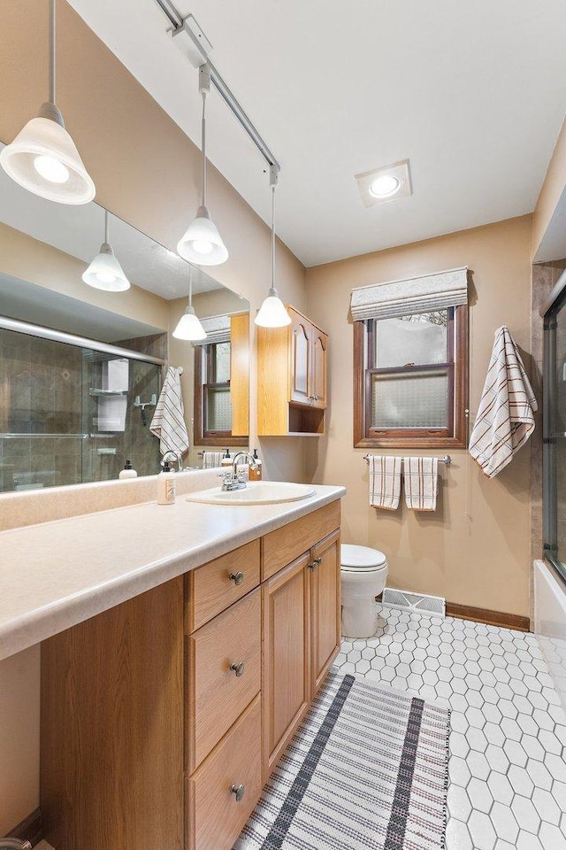 full bathroom featuring bath / shower combo with glass door, toilet, tile patterned floors, and vanity