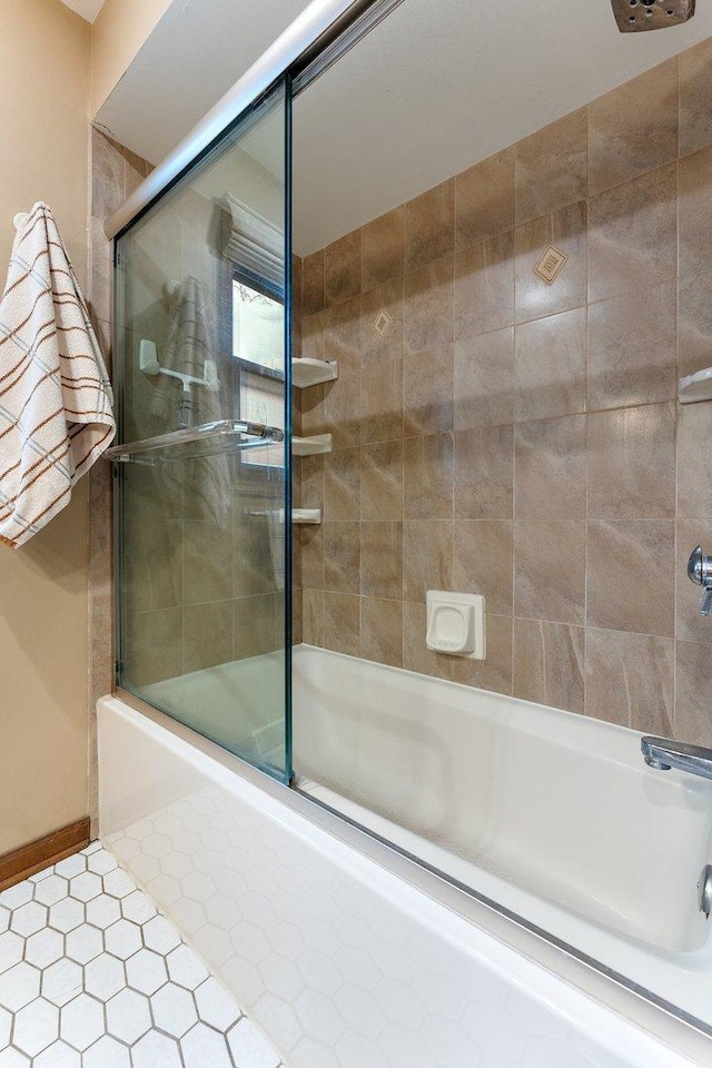 bathroom with bath / shower combo with glass door