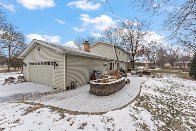 view of snowy exterior featuring a garage