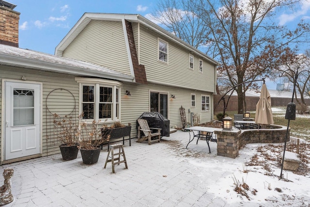 snow covered house with a patio