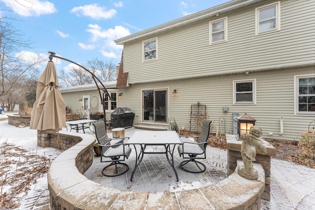 snow covered property featuring a patio