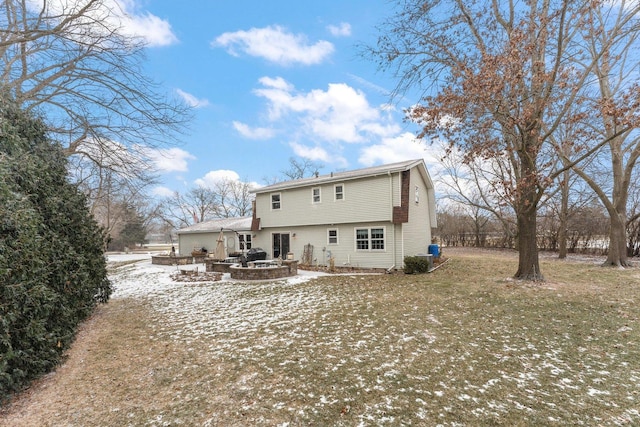 snow covered rear of property with a patio area and a yard