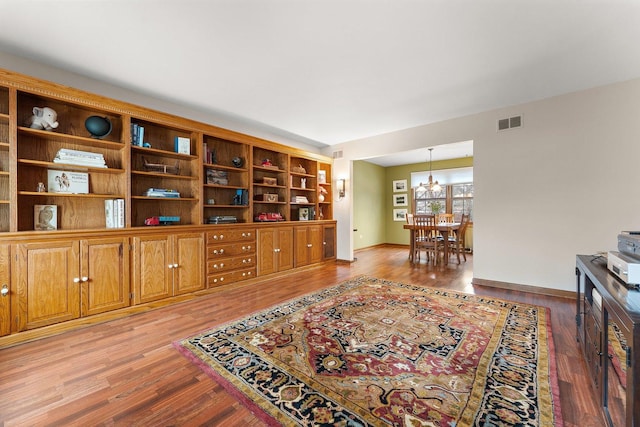 sitting room with a notable chandelier and light hardwood / wood-style flooring