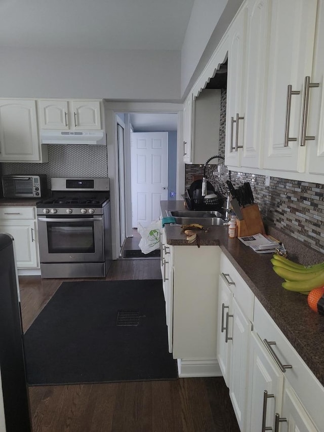 kitchen featuring decorative backsplash, sink, white cabinetry, and gas stove