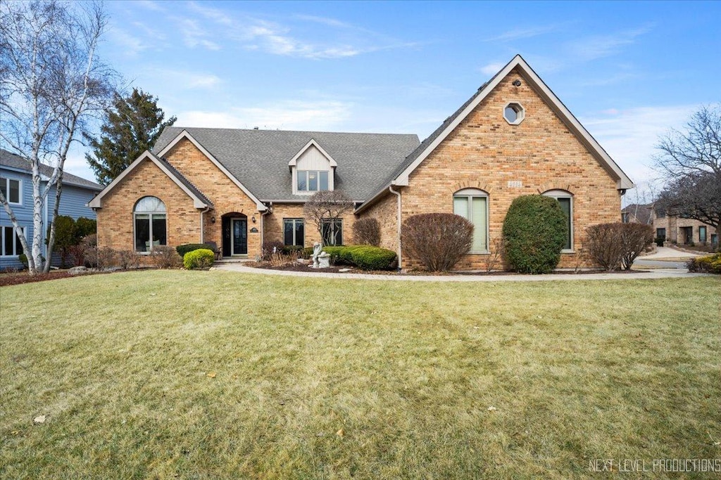 traditional-style home with brick siding and a front yard